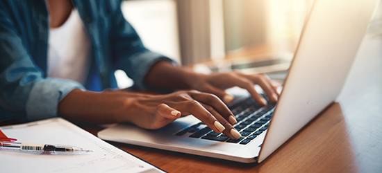 Person typing on their laptop.